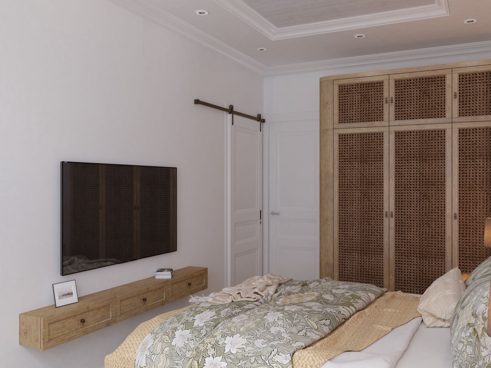 Bedroom design render with a wall-mounted TV on a plain white wall above a slim floating oak shelf with three small drawers, a tall cane-panelled wardrobe in the corner and a bed with a floral cover in the foreground